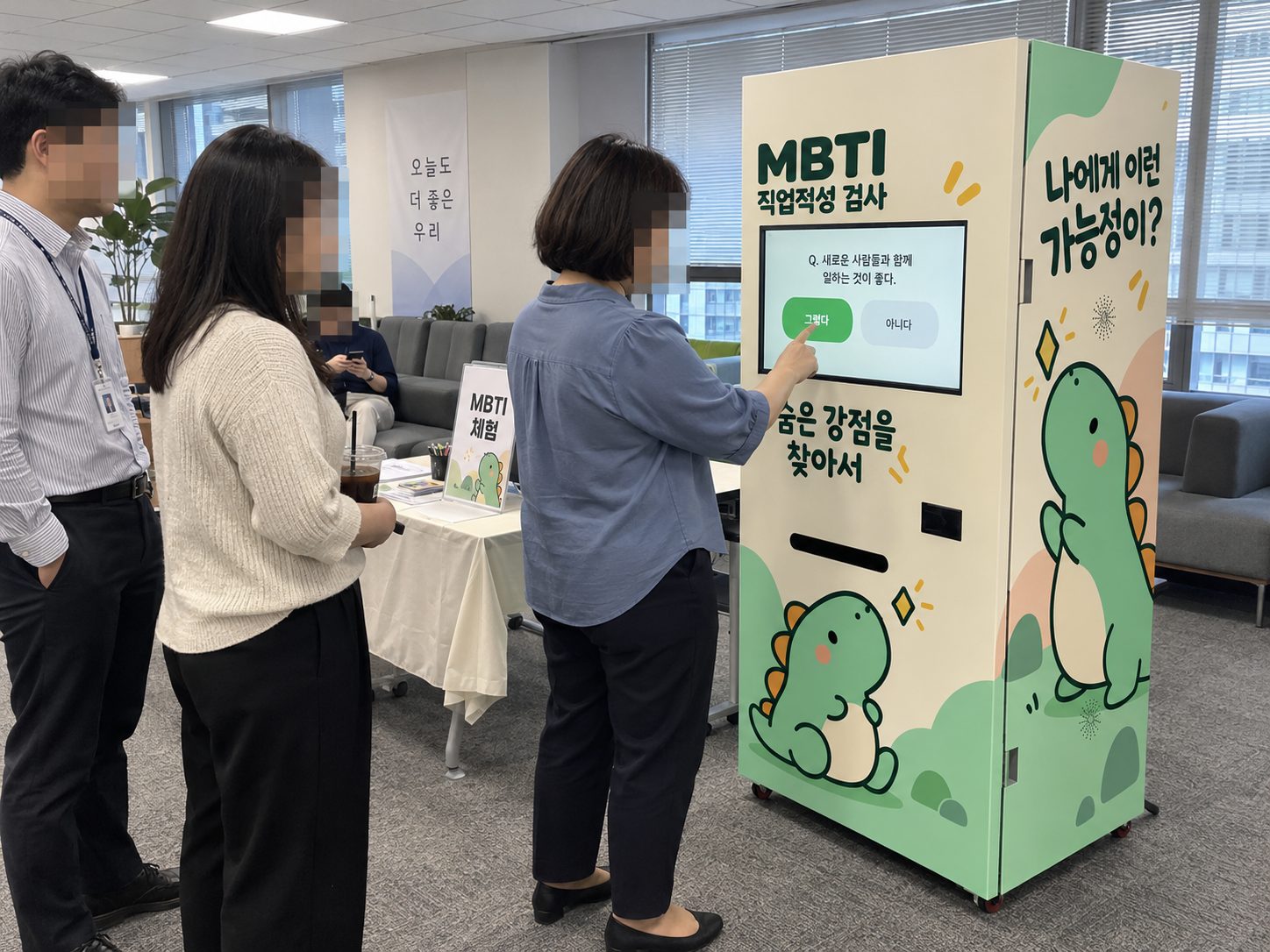 기관 로비에서 성인 참가자들이 MBTI 직업적성 검사기 화면을 보는 장면